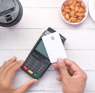 a person holding a credit card next to a calculator